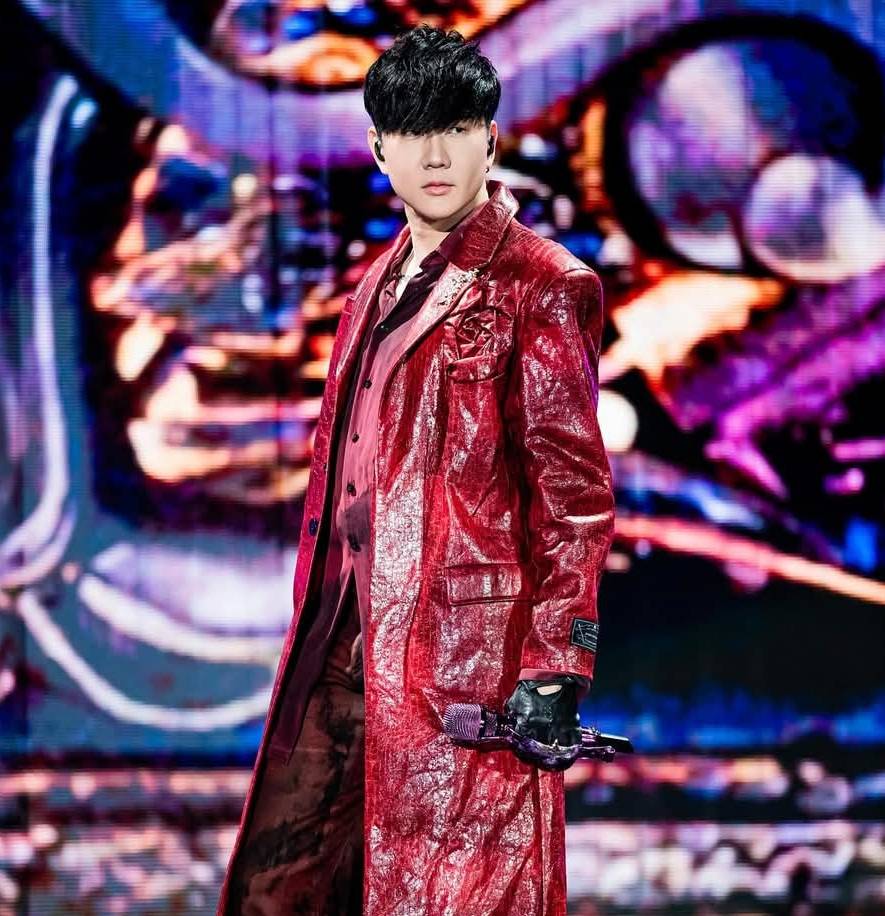 林俊傑站在台北大巨蛋舞台上，背景投影與燈光交錯呈現沉浸式視覺效果