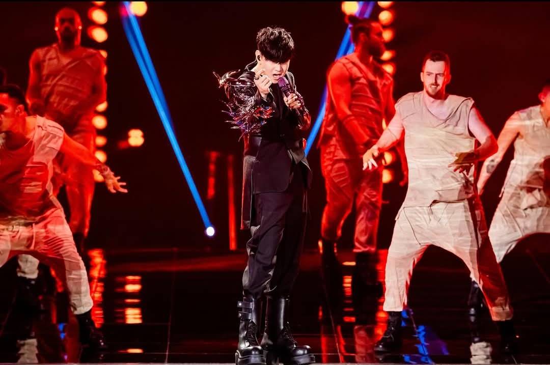 林俊傑站在台北大巨蛋舞台上，背景投影與燈光交錯呈現沉浸式視覺效果