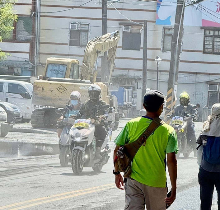 志工於災區現場佩戴口罩進行清理工作，塵土飛揚中努力守護家園