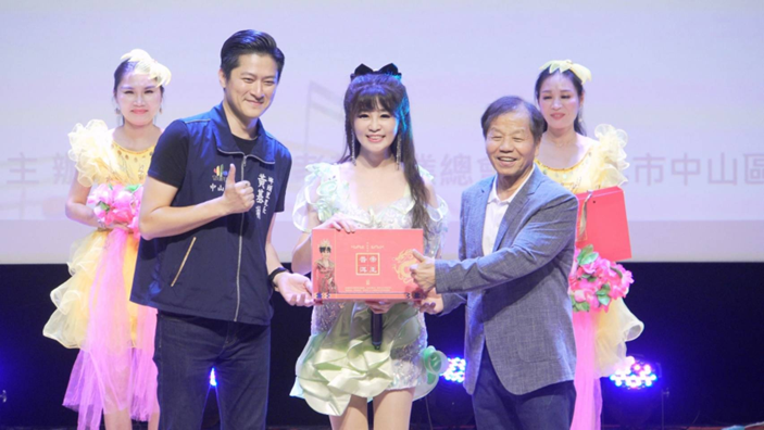 安琪菈身穿淡綠短禮服，在重陽敬老音樂會上獻唱，感動全場長輩