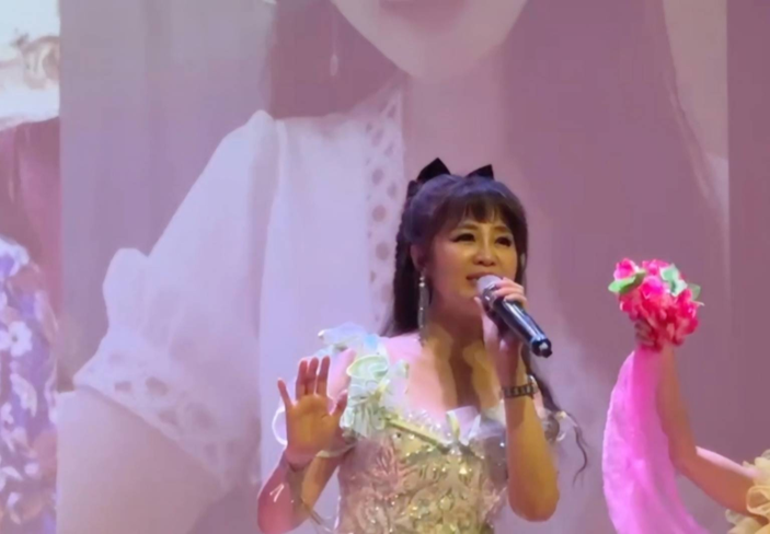 安琪菈身穿淡綠短禮服，在重陽敬老音樂會上獻唱，感動全場長輩