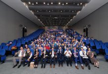 第八屆「溫暖人間獎」頒獎典禮—以愛與善行點亮社區 照片顯示四位溫暖人間獎得主在典禮上合影,背景為溫馨布置舞台與耶穌基督後期聖徒教會標誌