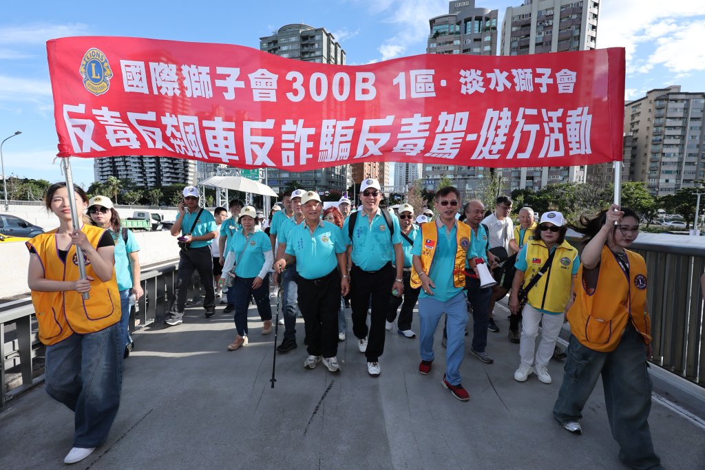 淡水獅子會公益健走現場，民眾在漁人碼頭舞台前舉手參與互動