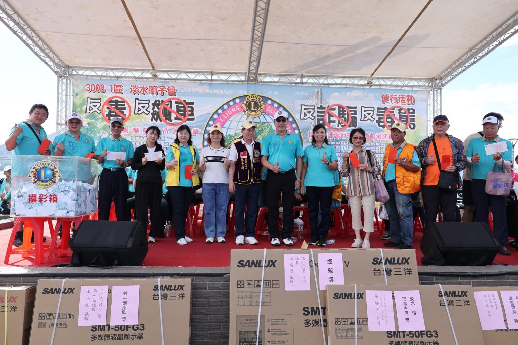 淡水獅子會公益健走現場，民眾在漁人碼頭舞台前舉手參與互動